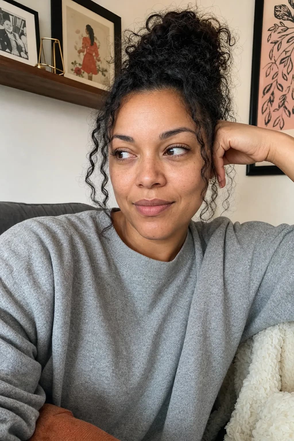 Photo of a curly-haired woman in a grey sweatshirt on a couch — the photo a customer uploaded.